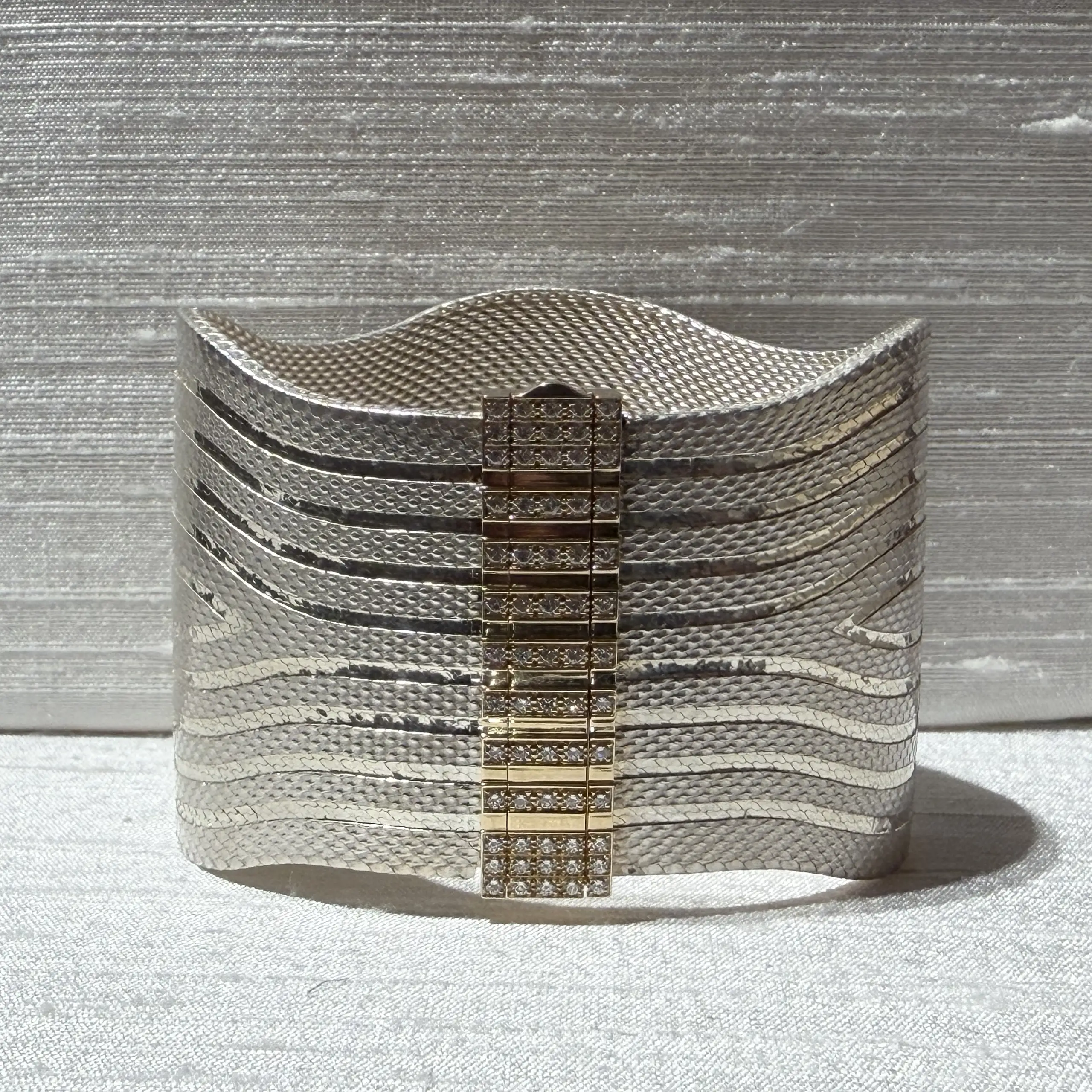 The diamond-set clasp opens through a smooth rotating action