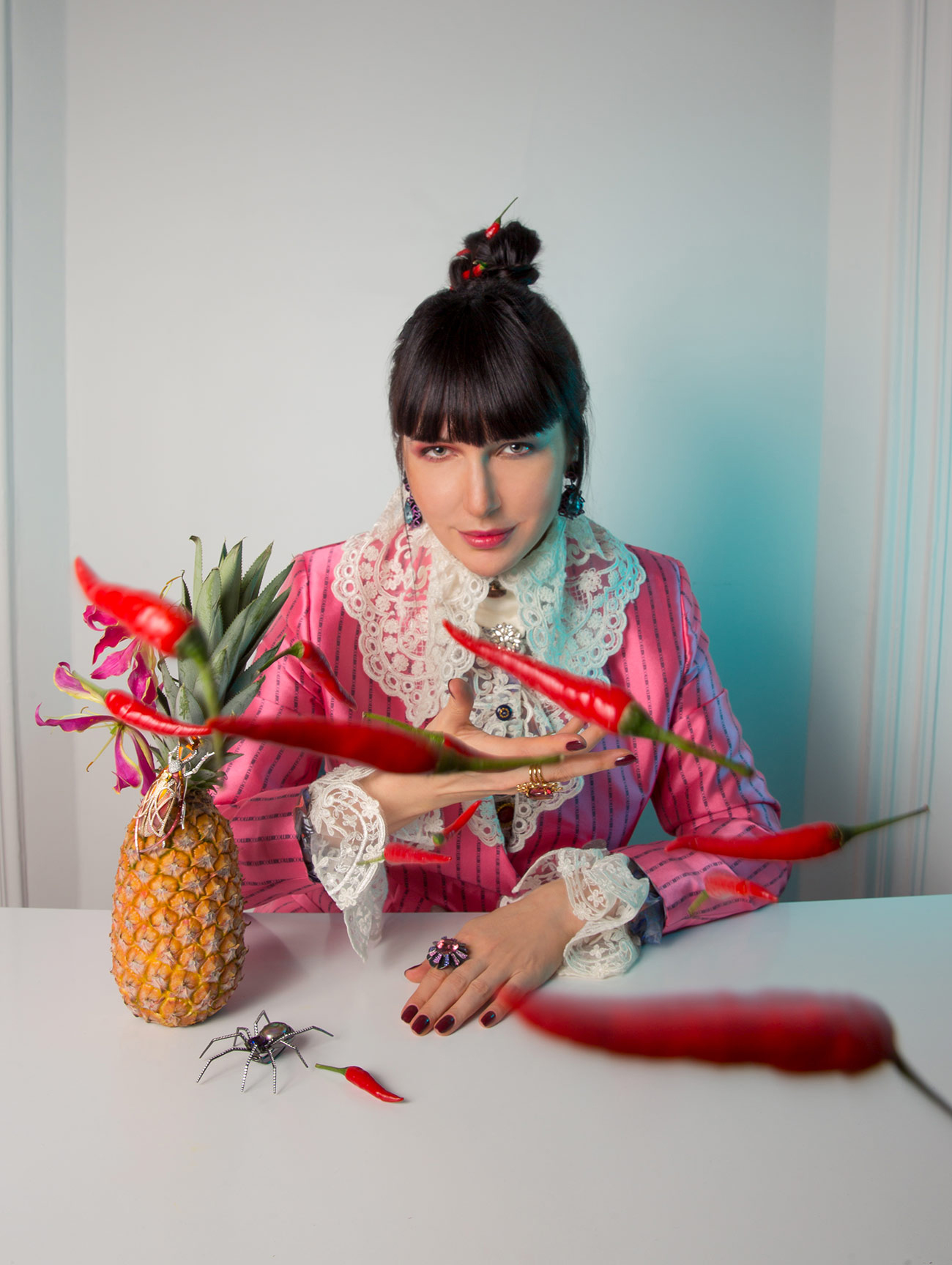 The Joker Katerina wears earrings and rings by Lorenz Baumer, a blouse by Etienne Jeanson and a blazer by Collini Milano, with the Araignée Extravagante Good Girl Bad Girl spider-inspired brooch crawling along the table.